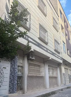 a building with windows and a door on a street at Appartement élégant à Meknès in Meknès