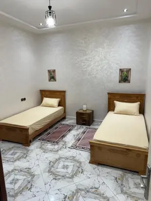 two twin beds in a room with a tiled floor at Appartement élégant à Meknès in Meknès