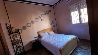 a bedroom with a bed and a wall with mirrors at Villa kaddi in Tinerhir