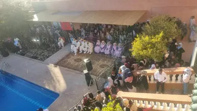 a crowd of people standing in front of a pool at Villa kaddi in Tinerhir
