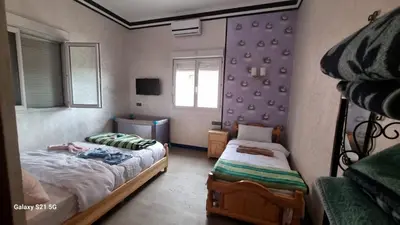 a small bedroom with two beds and a window at Villa kaddi in Tinerhir
