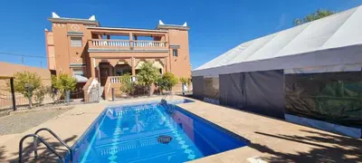 a swimming pool in front of a house at Villa kaddi in Tinerhir