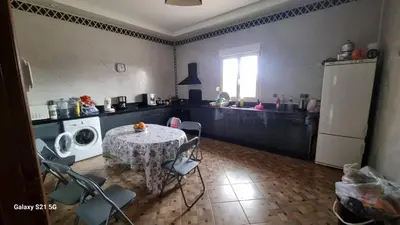 a kitchen with a table and chairs and a refrigerator at Villa kaddi in Tinerhir