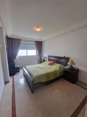 a bedroom with a large bed and a window at Ilar Appartement in Oulad Akkou