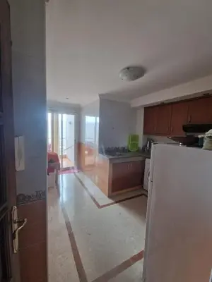 a kitchen with a refrigerator in a room at Ilar Appartement in Oulad Akkou