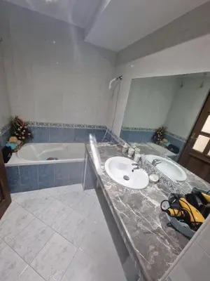 a bathroom with two sinks and a bath tub at Ilar Appartement in Oulad Akkou