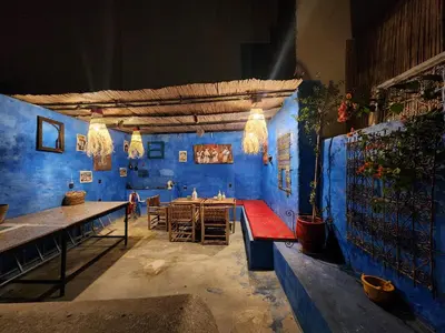 a room with blue walls and a table and benches at Dar Lala Chafia Fes in Fès