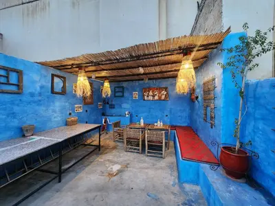 a blue room with a table and a potted plant at Dar Lala Chafia Fes in Fès