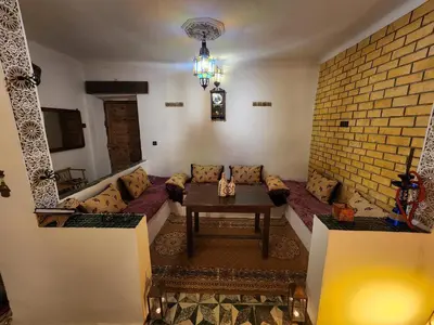 a living room with a couch and a brick wall at Dar Lala Chafia Fes in Fès