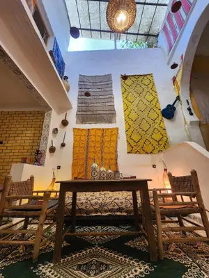 a room with two wooden chairs and a table at Dar Lala Chafia Fes in Fès