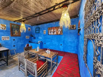 a dining room with blue walls and a table and chairs at Dar Lala Chafia Fes in Fès