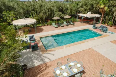 an overhead view of a swimming pool with a table and chairs at Dar Salah - Eddine Oasis Pool & SPA in Marrakech