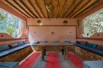 a room with a table and blue couches at Dar Salah - Eddine Oasis Pool & SPA in Marrakech