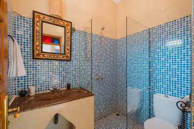 a blue tiled bathroom with a sink and a shower at Dar Salah - Eddine Oasis Pool & SPA in Marrakech