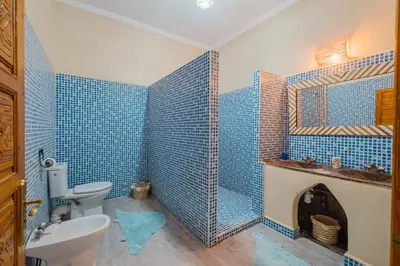 a blue tiled bathroom with a toilet and a sink at Dar Salah - Eddine Oasis Pool & SPA in Marrakech