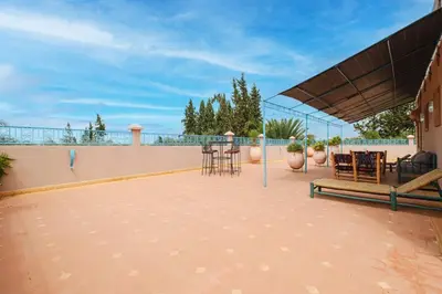 a patio with chairs and tables on a roof at Dar Salah - Eddine Oasis Pool & SPA in Marrakech