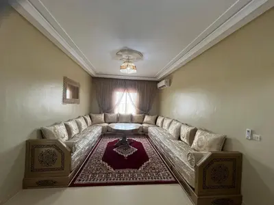 a living room with a couch and a table at Grand appartement de 3 chambres Idéal familles et groupes Résidence sécurisée in Marrakech