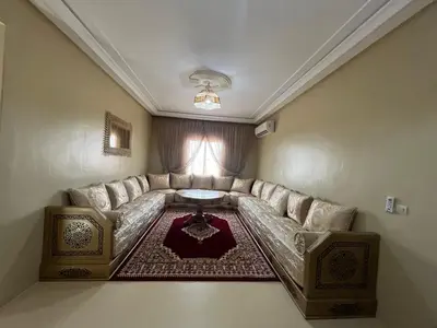 a living room with a couch and a table at Grand appartement de 3 chambres Idéal familles et groupes Résidence sécurisée in Marrakech