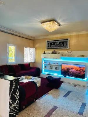 a living room with a large tv and a couch at Appartement luxe 2 Chambres 5 min du Centre Ville in Fès