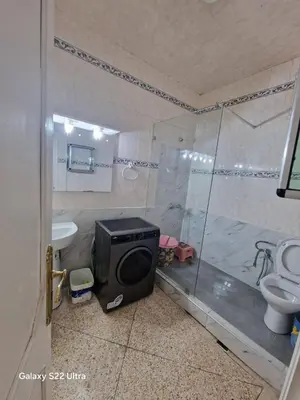 a bathroom with a shower and a television in it at Appartement luxe 2 Chambres 5 min du Centre Ville in Fès