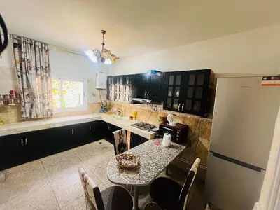 a kitchen with a table and a refrigerator at Appartement luxe 2 Chambres 5 min du Centre Ville in Fès