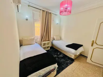 a small room with two beds and a pink light at Appartement luxe 2 Chambres 5 min du Centre Ville in Fès