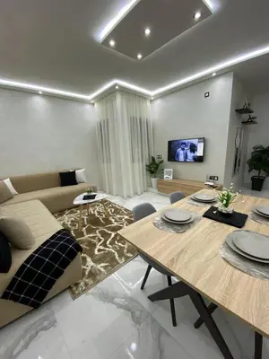 a living room with a table and a couch at Appartement lux résidence fermée sécurisé parking gratuit in Fès
