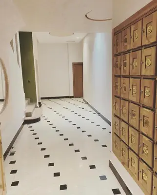a hallway with wooden doors and a tile floor at Appartement lux résidence fermée sécurisé parking gratuit in Fès