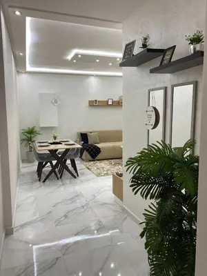 a living room with a table and a couch at Appartement lux résidence fermée sécurisé parking gratuit in Fès