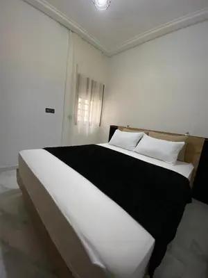 a bedroom with a large bed with black and white pillows at Appartement lux résidence fermée sécurisé parking gratuit in Fès