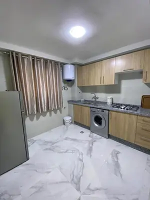 a kitchen with a white marble floor in a room at Appartement lux résidence fermée sécurisé parking gratuit in Fès