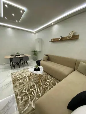 a living room with a couch and a table at Appartement lux résidence fermée sécurisé parking gratuit in Fès