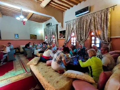 a group of people sitting in a living room eating at Kasbah Dounia in Kerrando
