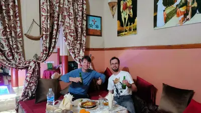two men sitting at a table with drinks at Kasbah Dounia in Kerrando
