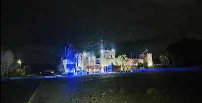 a large white building with blue lights in the night at Kasbah Dounia in Kerrando