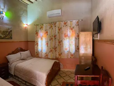 a small bedroom with a bed and a curtain at Kasbah Dounia in Kerrando