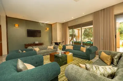 a living room with blue couches and a tv at Villa Stevana in Oulad Mazoug