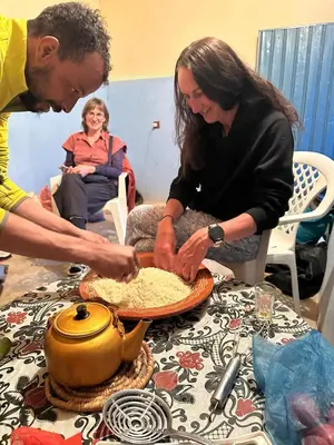 a man and a woman preparing food on a table at Gite d'tape handour in Hamdour