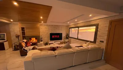 a living room with a white couch and a tv at Villa Lumiere-Luxury Retreat with Private Spa and Garden in Ifrane