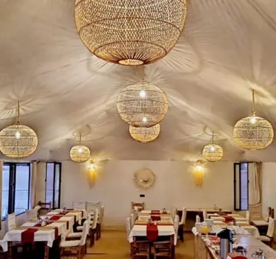 a dining room with white tables and chandeliers at Desert Marhaba luxury Camp in Merzouga