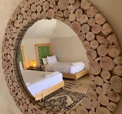 a mirror reflecting a bedroom with a bed and a bed sqor at Desert Marhaba luxury Camp in Merzouga