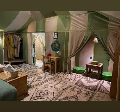 a room with a tent with a table and chairs at Desert Marhaba luxury Camp in Merzouga
