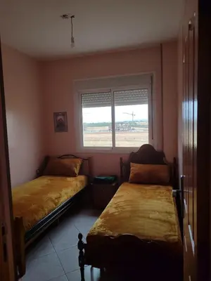 two beds in a room with a window at Appart prés du chu fes fes shore in Fès