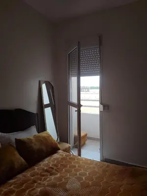 a bedroom with a bed and a sliding glass door at Appart prés du chu fes fes shore in Fès