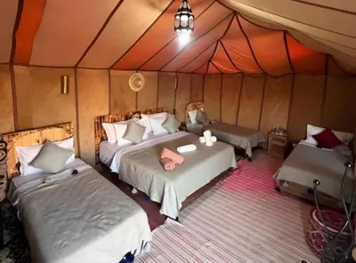a bedroom with two beds in a tent at Merzouga sands camp in Merzouga