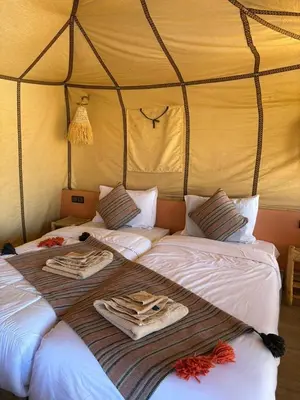 a bedroom with two beds in a tent at Merzouga sands camp in Merzouga