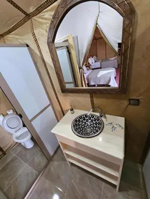 a bathroom with a sink and a mirror in a tent at Merzouga sands camp in Merzouga