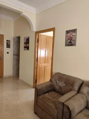 a living room with a brown couch and a door at Relaxnstay midelt in Midelt