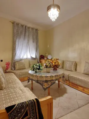 a living room with a couch and a table with flowers at Relaxnstay midelt in Midelt