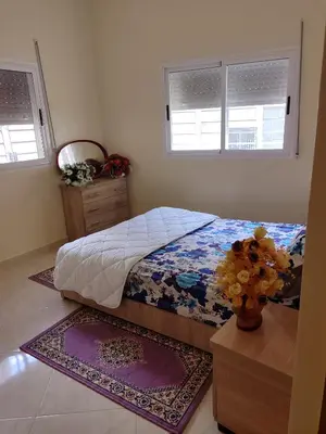 a bedroom with a bed and a vase of flowers at Relaxnstay midelt in Midelt